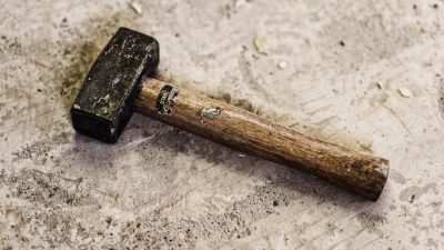 Ein einfacher Hammer, der am Boden liegt.